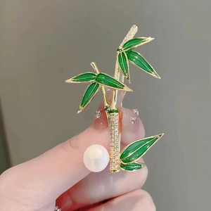 Exquisite bamboo brooch in gold metal with green enamel leaves and a white pearl