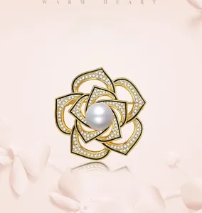 Detail of elegant gold rose brooch featuring a large white pearl and sparkling rhinestones