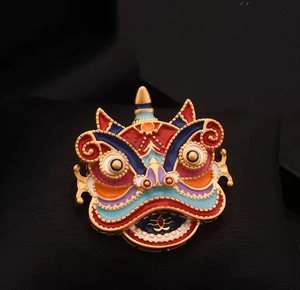 Détail d'une broche de danse du lion traditionnelle en émail coloré et métal doré