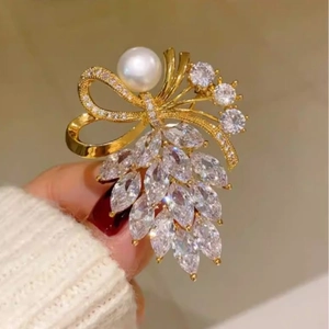 Élégante broche dorée en forme de nœud avec perle et zircons marquises étincelants