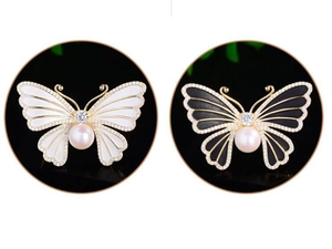 Détail de broche papillon avec sertissage de zircons et perle centrale de haute qualité