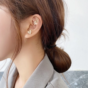 Detail of elegant gold butterfly ear hook with zircon crystals worn by a model