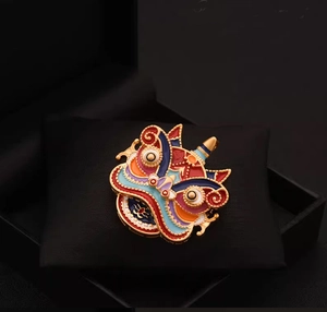 Vue détaillée d'une broche lion de danse en émail coloré sur un coussin noir élégant