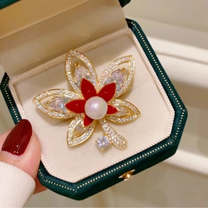 Elegante spilla a foglia d'acero con petali rossi, perla bianca e oro su velluto verde