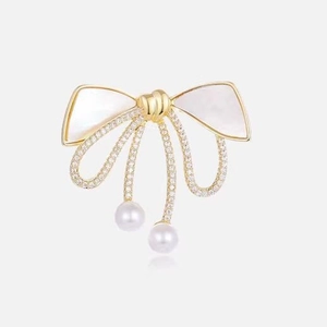 Elegant gold bow brooch with mother of pearl inlay, sparkling crystals and pearl drops