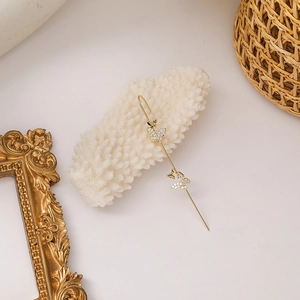 Detail view of golden butterfly ear cuff with sparkling crystals on coral decoration