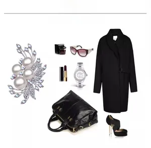 Detail view of flower pearl brooch with silver petals on black wool coat background