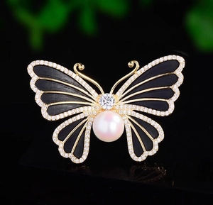 Gros plan détaillé d'une broche papillon en émail noir avec incrustations de perles