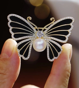 Détail de la broche papillon avec émail noir, perle blanche et cristaux micro-sertis