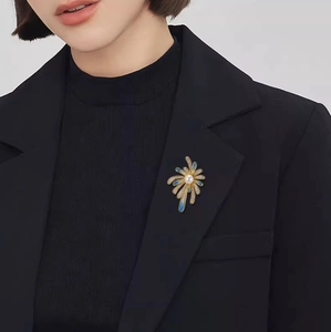 Broche feu d'artifice bleu avec perles et cristaux sur un blazer noir élégant