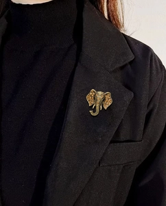 Close-up of vintage gold elephant brooch with amber rhinestones on a black suit blazer