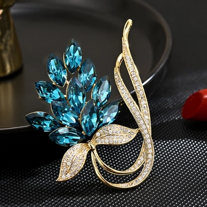 Exquisite leaf-shaped golden brooch with deep blue marquise crystals and sparkling zircons