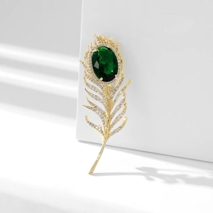 Élégante broche plume dorée avec pierre vert émeraude et pavé de zircons blancs brillants