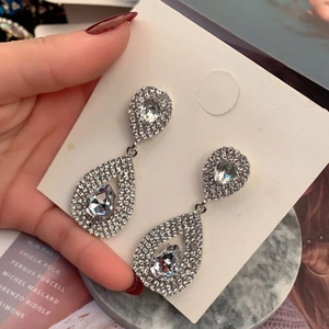 Macro shot of 925 silver needle pear-shaped earrings with sparkling micro-pave crystals
