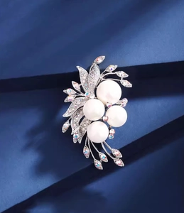 Macro detail of elegant floral pearl brooch with sparkling crystals and silver finish