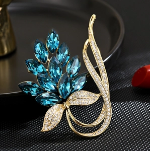 Elegant plant-shaped brooch with peacock blue marquise crystals and gold diamond accents