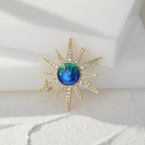 Macro detail of sunburst celestial brooch with blue enamel and sparkling crystals