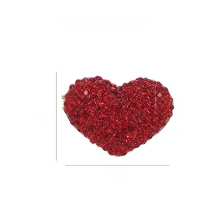 Dettaglio di una spilla a cuore con strass rossi scintillanti, 3,2 cm per 2,4 cm