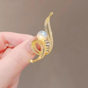 Broche élégante plume dorée avec grande perle et cristaux de zircone scintillants