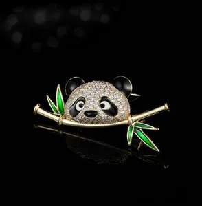 Macro shot of gold panda brooch with sparkling white crystals and green enamel bamboo