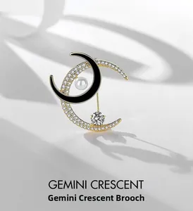 Macro shot of silver crescent moon brooch with black enamel, crystals and white pearl