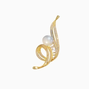 Détail macro d'une élégante broche fleur dorée avec des perles et des pierres de zircone