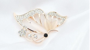 Detailed macro view of a gold butterfly brooch with shimmering rhinestones and opal stones