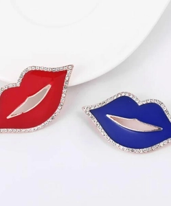 Dettaglio delle spille a labbra in smalto rosso e blu con bordi di strass brillanti