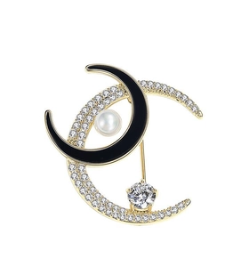 Detailed view of moon brooch with gold plating, sparkling zircons, and a hanging crystal
