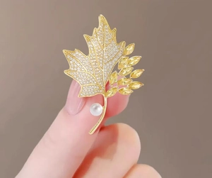 Detail of maple leaf brooch with yellow marquis stones, white zircon, and a round pearl