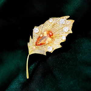 Elegant gold leaf brooch with orange pear-shaped stone and zircon pavé on velvet