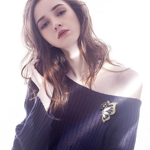 Elegant butterfly brooch with cat eye stone and colorful crystals on model shoulder