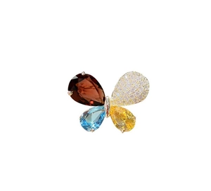 Detailaufnahme einer goldenen Schmetterlingsbrosche mit bunten Edelsteinen und Diamantenbesatz