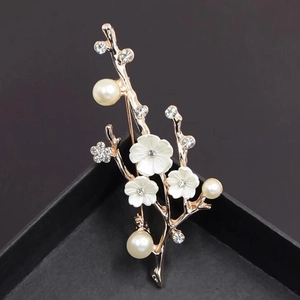 Détail de broche fleur de prunier or rose avec fleurs en nacre et perles