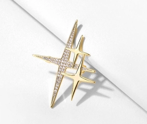 Dettaglio di una spilla a stella dorata con strass brillanti su uno sfondo bianco