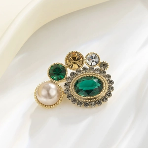 Broche vintage géométrique avec pierres vertes et perles sur fond en soie blanche