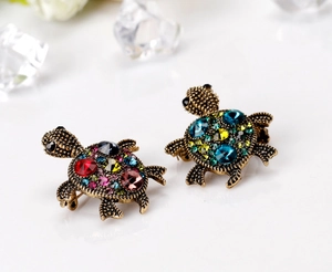 Close-up of luxury turtle brooches with colorful rhinestones in vintage gold and bronze