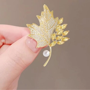 Elegant maple leaf brooch with yellow crystals and white pearl on gold alloy base