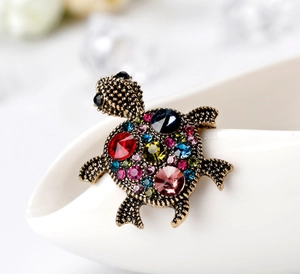 Macro shot of colorful rhinestone turtle brooch with intricate crystal detail on metal