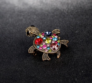 Detailed macro view of turtle brooch with colorful rhinestones on vintage gold metal