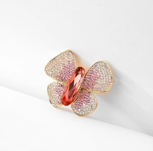 Detailed macro view of an elegant butterfly brooch with orange crystal and pavé rhinestones