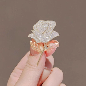 Sparkling rose flower brooch in gold with white cubic zirconia crystals for women
