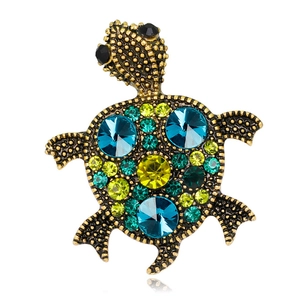 Detailed view of turtle brooch featuring multi-colored crystals and gold-toned alloy textures