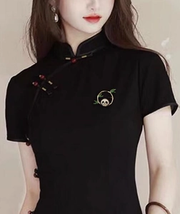 Spilla panda cinese con anello di bambù dorato su un Qipao nero tradizionale
