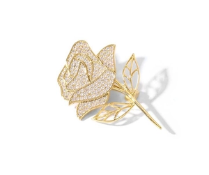 Detail of rose brooch with pavé set cubic zirconia and golden finish on white background