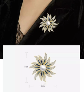Detail of 5cm sunflower pearl brooch with blue enamel and sparkling zircon accents