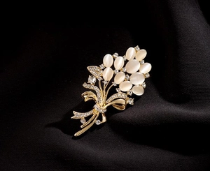 Détail de la broche bouquet de fleurs dorées avec pierres œil de chat et cristaux scintillants