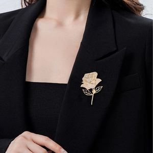 Elegant gold rose brooch with sparkling zircon crystals on a black suit jacket lapel