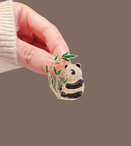 Detail of panda brooch with sparkling white zircons and green enamel bamboo leaves