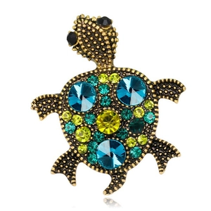 Luxury gold turtle brooch featuring colorful crystals with a clear mirror reflection